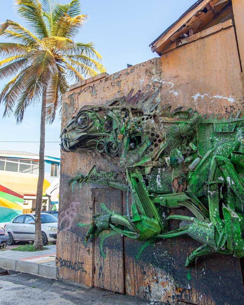 Street art of a green iguana made of recycled materials in San Nicolas