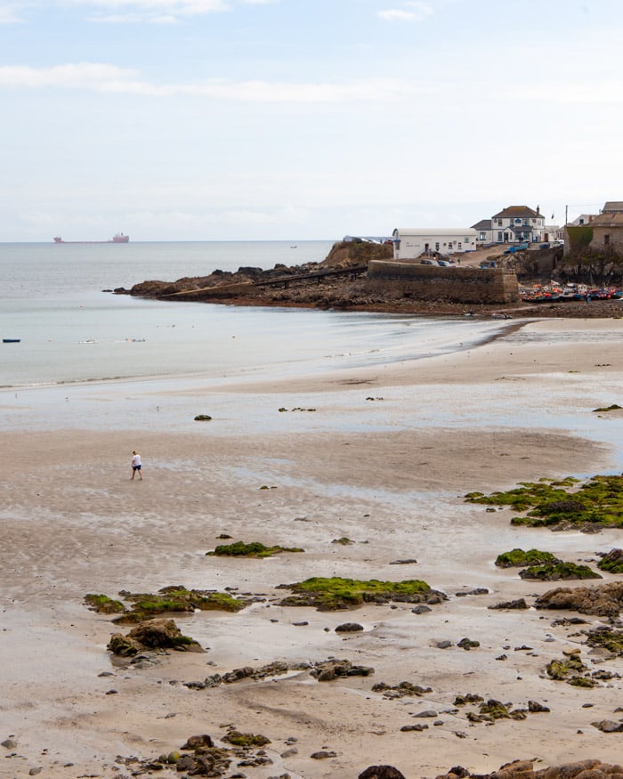 A man walks on Coverack Beach on the Lizard Peninsula