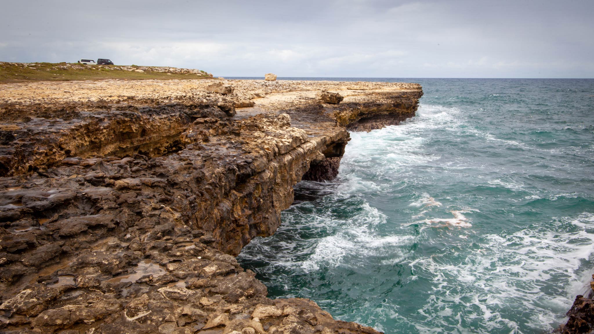 The ocean crashes against a rocky bridge in Antigua