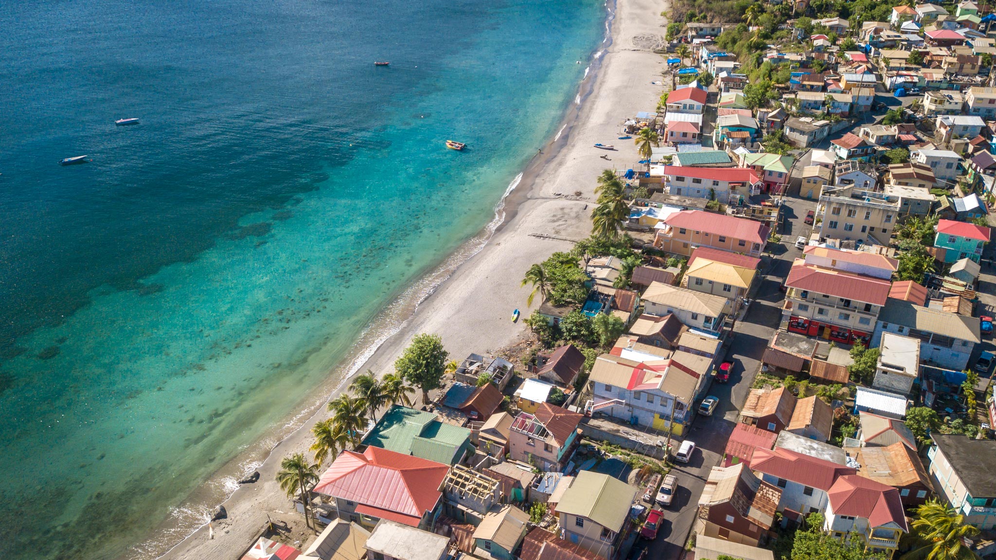 Aerial view of a beach on Dominicas west coast with a small town alongside it