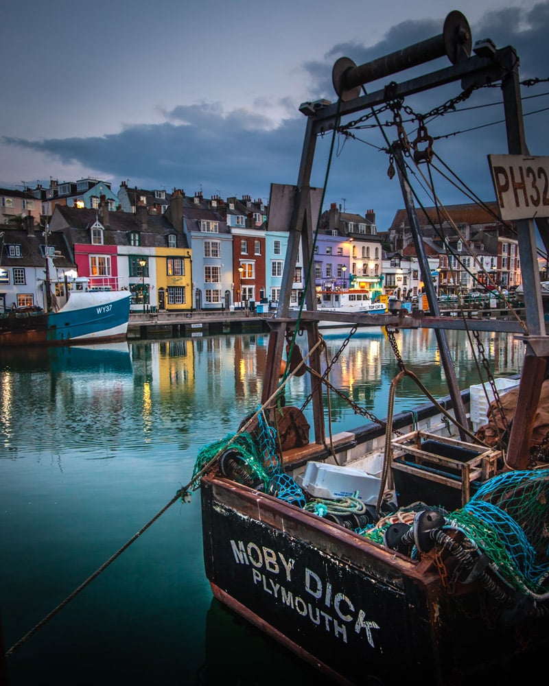 A river in the town of Weymouth reflects the colourful houses