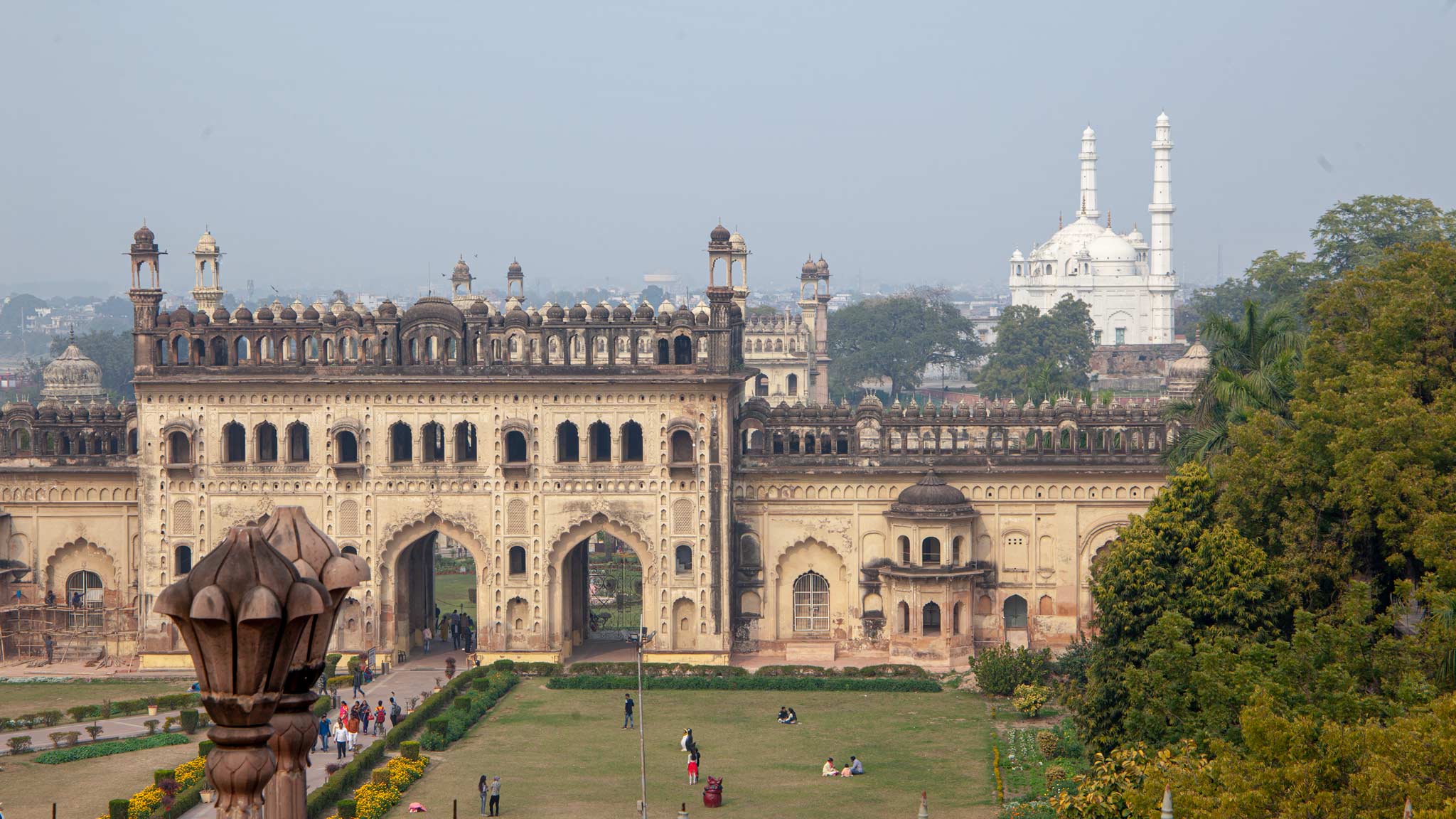 The Bara Imambara main entrance is a large building in Lucknow with archways, in the distance is a white mosque