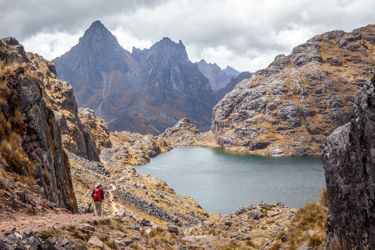 View over jagged peaks and a small lake along the Lares Trek