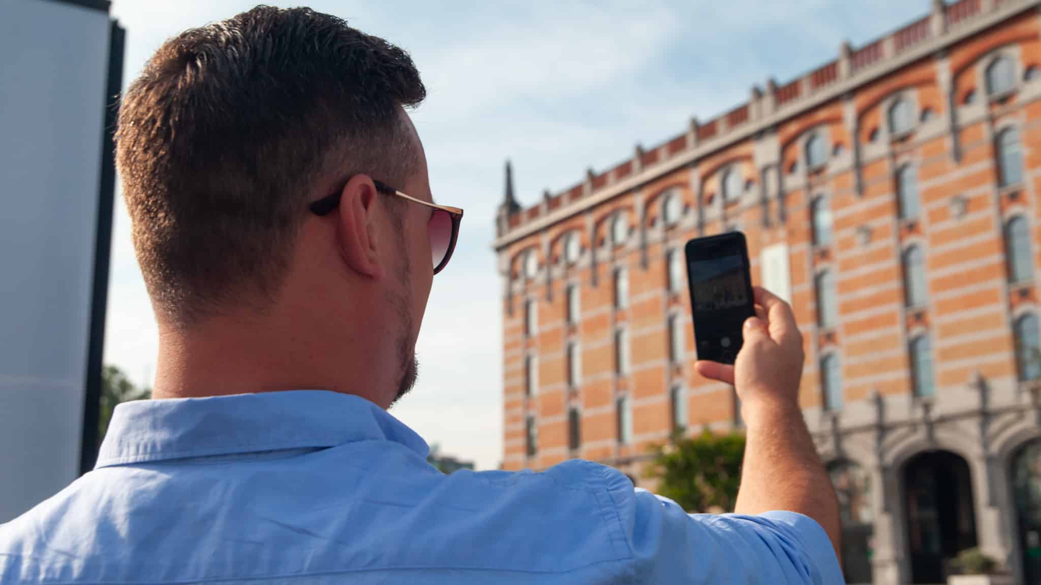 Dan using a mobile phone to take a photo in Brussels