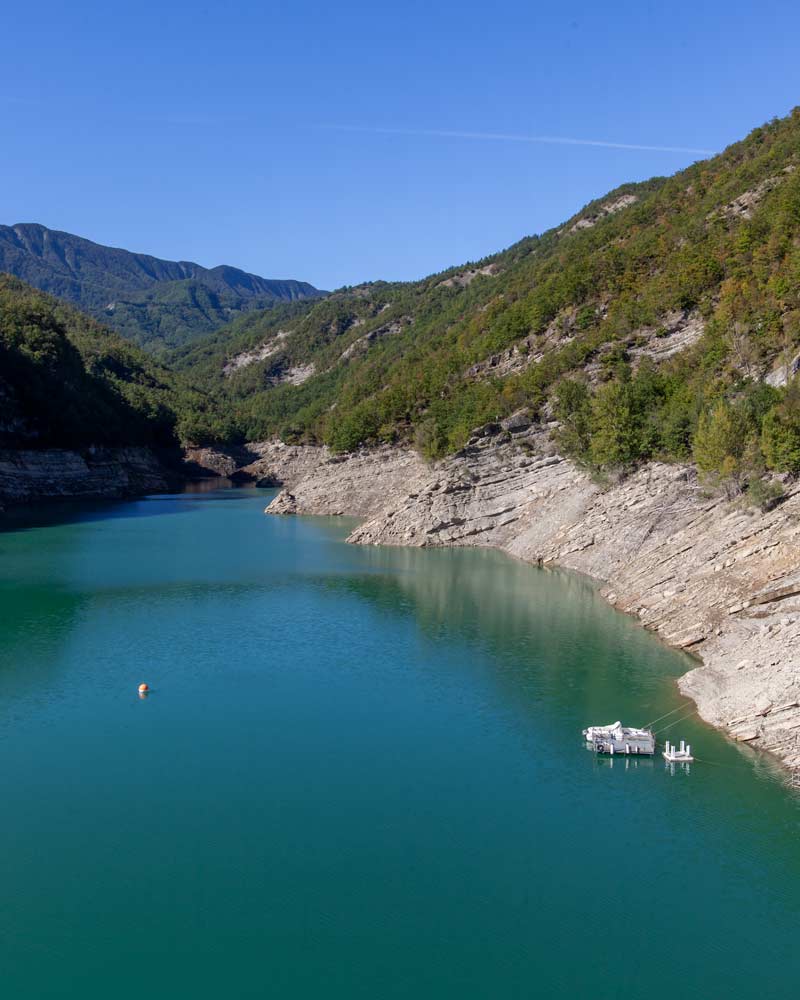 The Ricardi Dam shines a blight blue with a boat floating in it