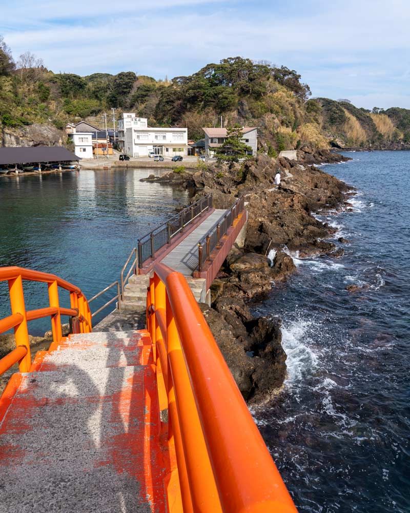 A red bridge crosses the water on Sado Island