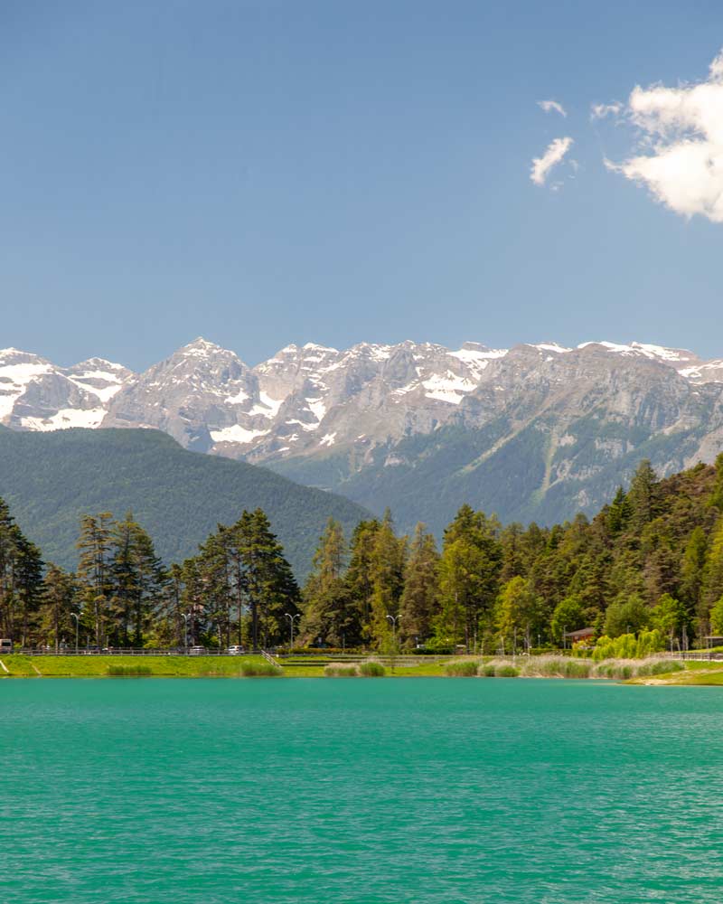 Mountains behind the trees and lake in Val Di Non