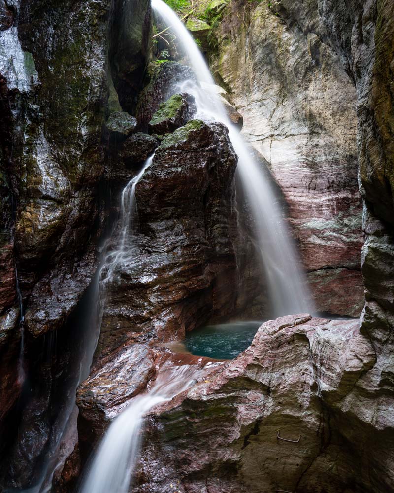 A waterfall streams over purple rocks in Kochi Japan